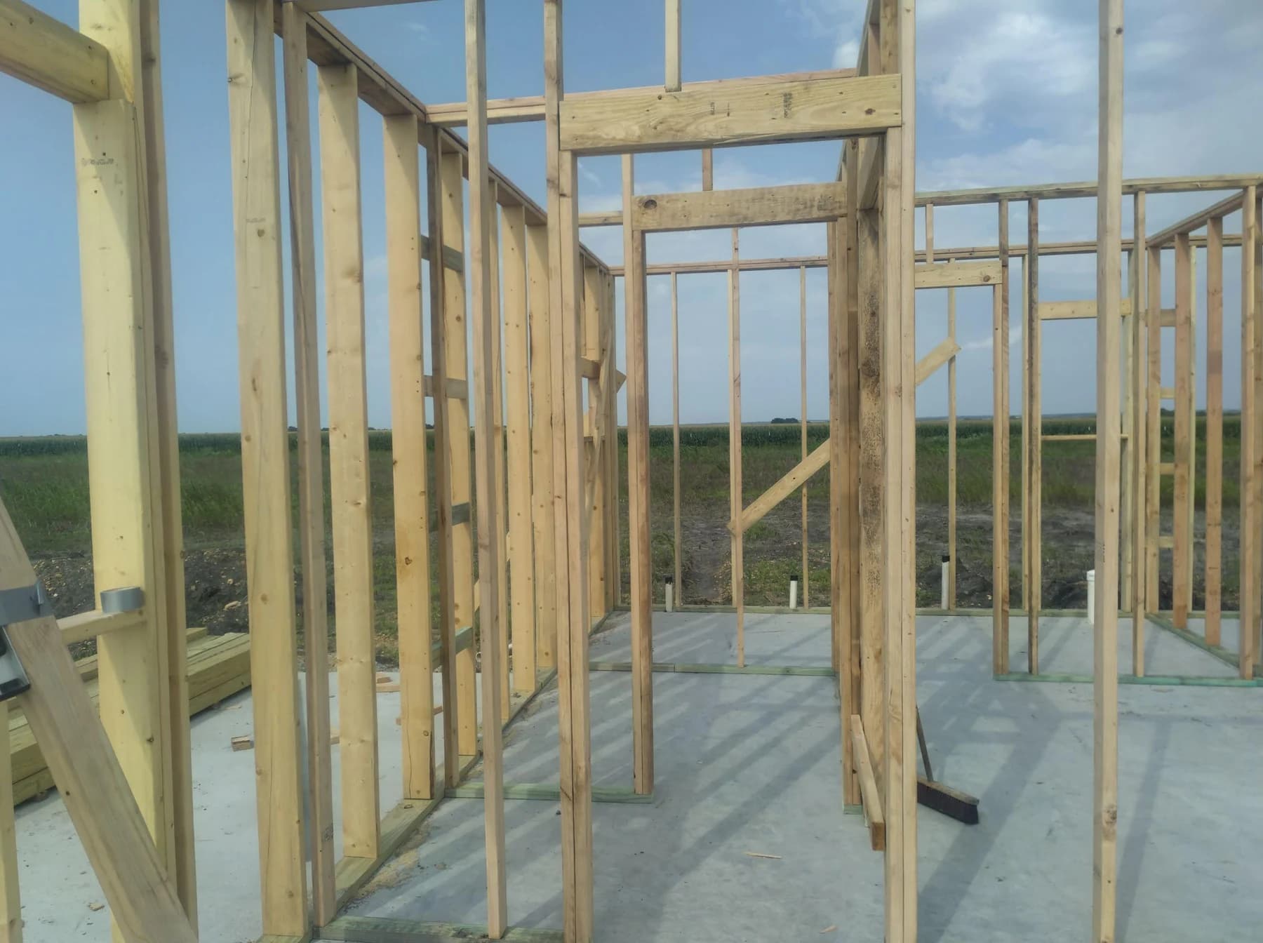 Open wall framing rising from the Plymouth slab during construction