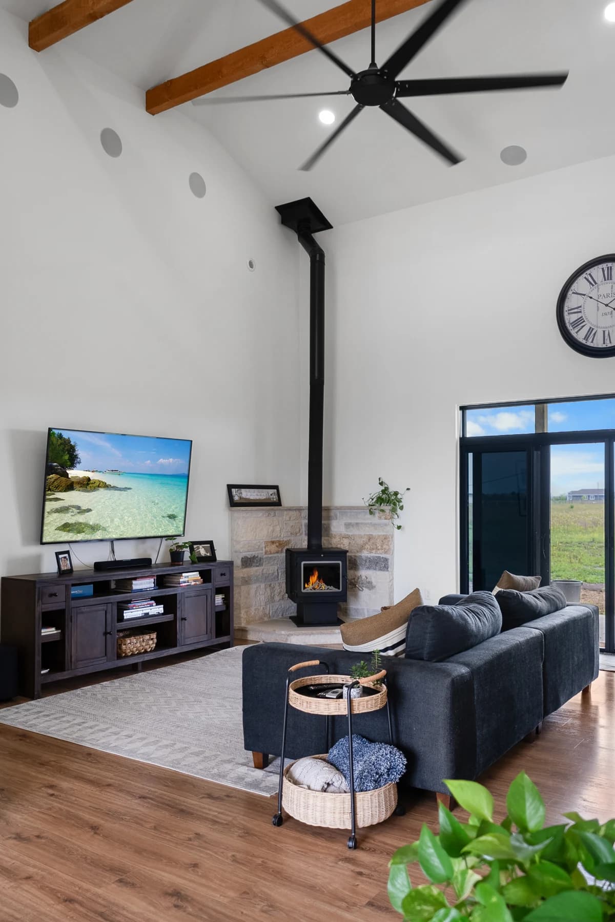 The finished Plymouth living room with a wood stove, comfortable seating and exposed ceiling beams