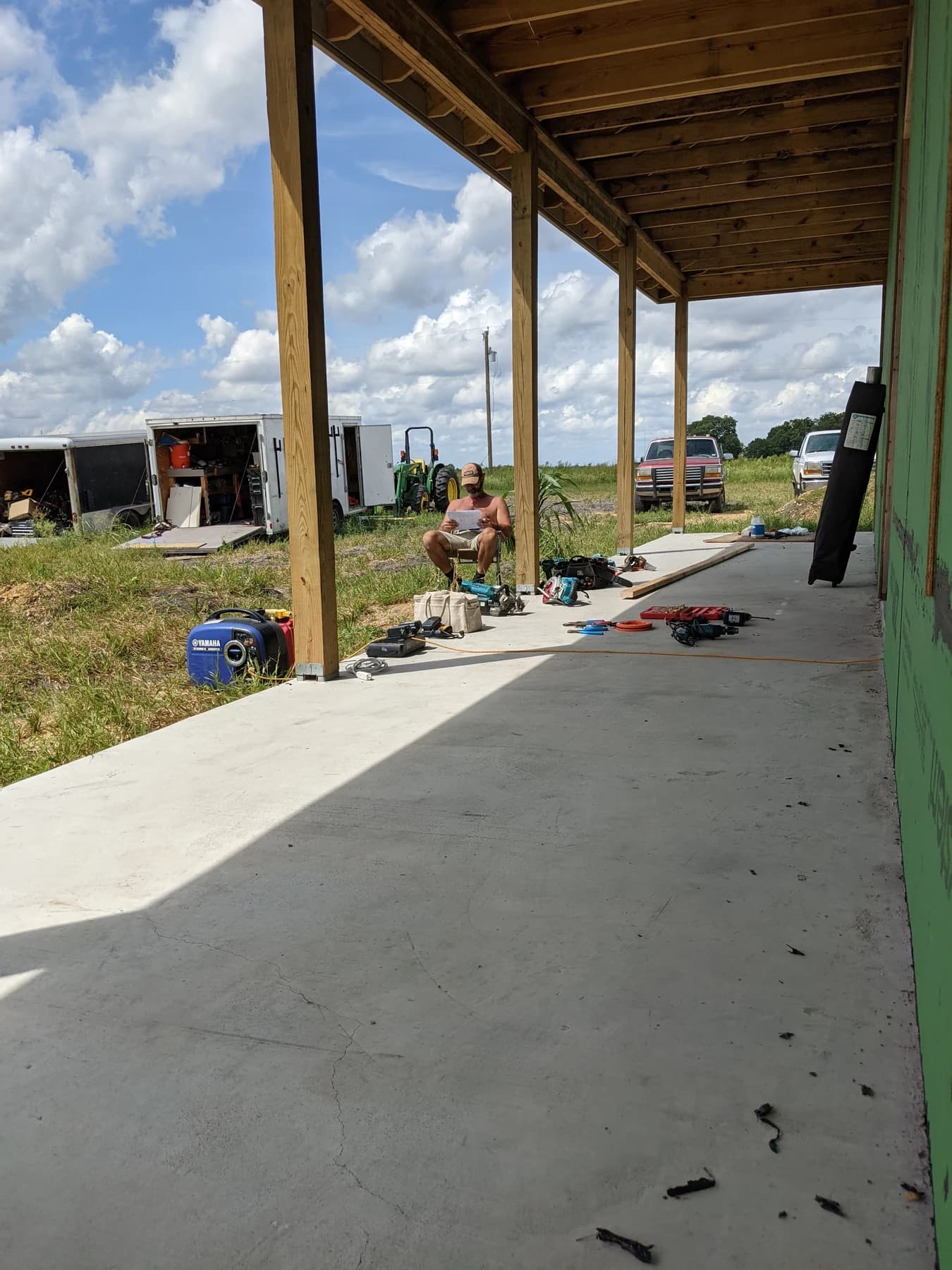 The long covered Plymouth porch during construction, with exposed roof framing and timber posts