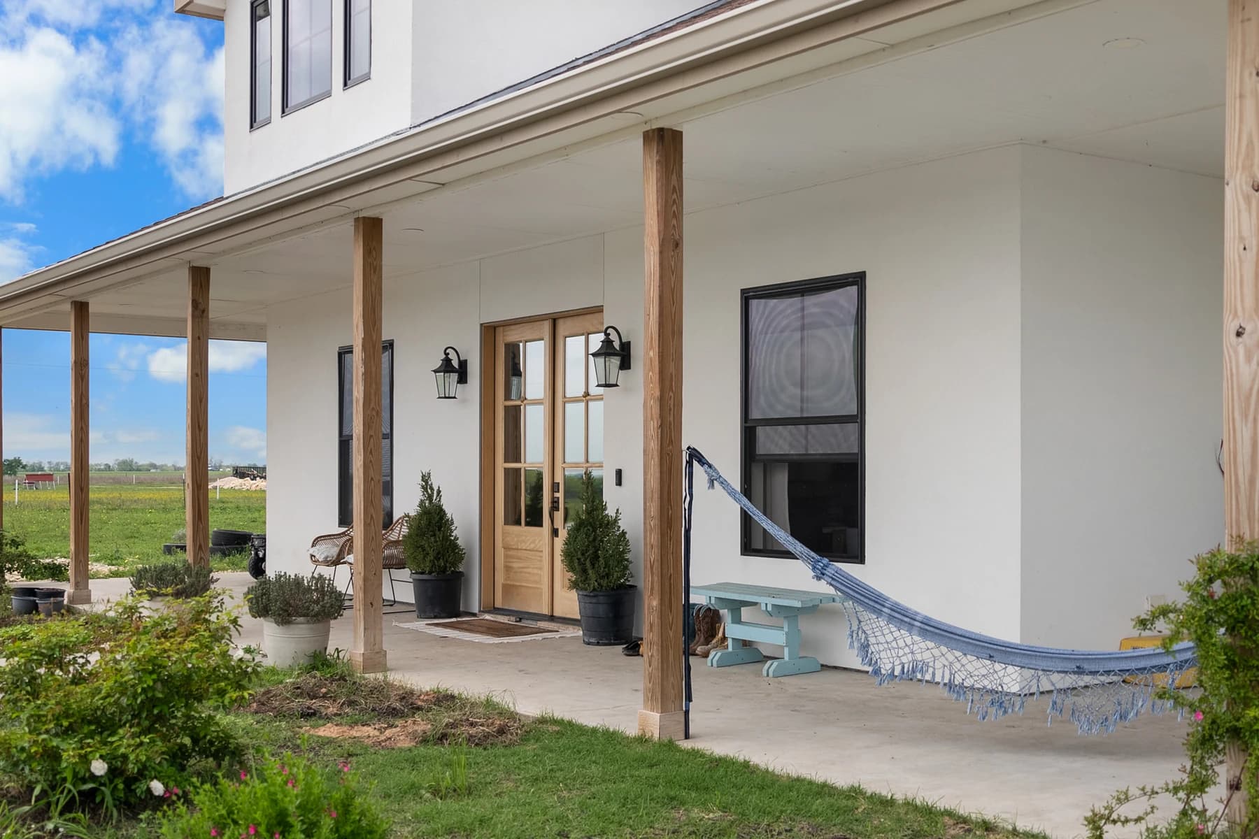 The completed Plymouth porch with timber posts, a wood front door and a hammock
