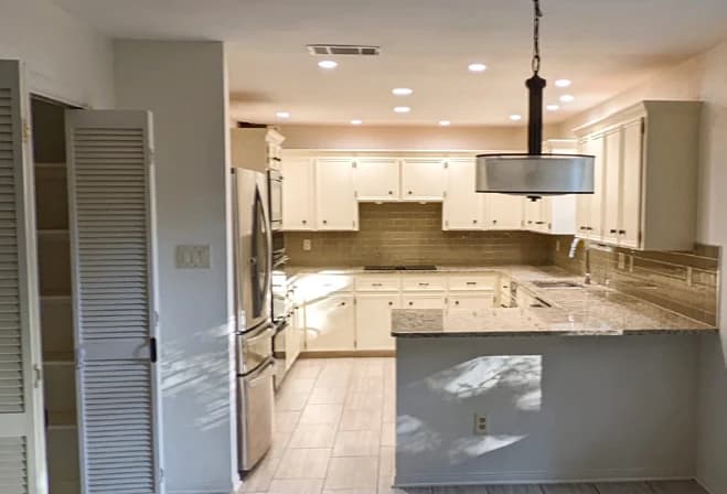 The Provence kitchen before the remodel, with white cabinets, a peninsula and walls separating the room